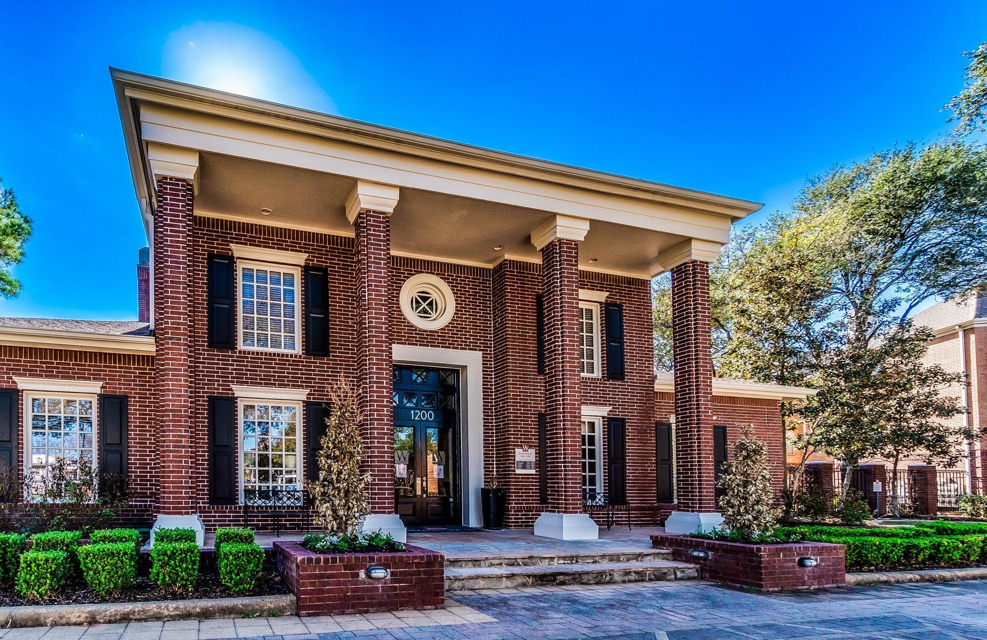 A red brick house with a white roof and a black door.